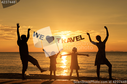 Image of Happy family standing on the beach