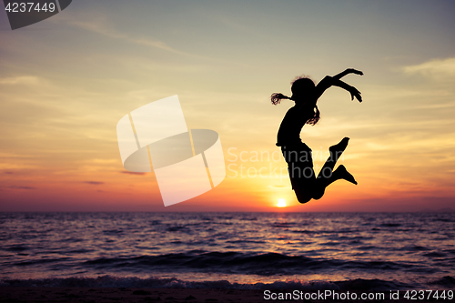 Image of Happy teen girl  jumping on the beach