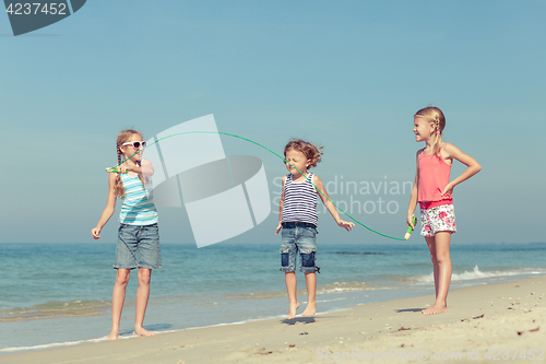 Image of Three happy children playing on the beach