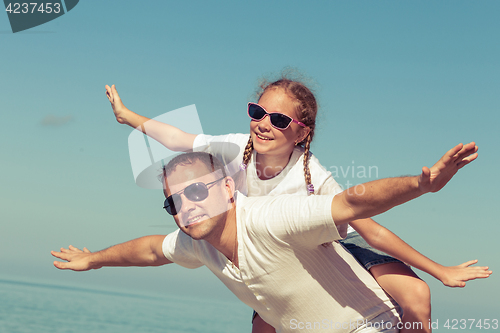 Image of Father and daughter playing on the beach.