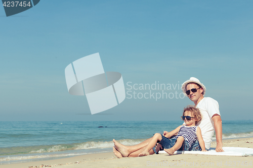 Image of Father and son playing on the beach at the day time.