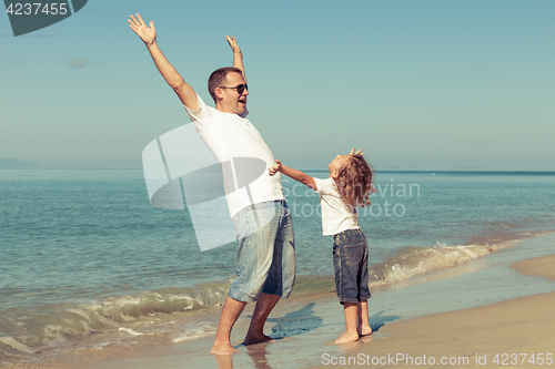 Image of Father and son playing on the beach at the day time.