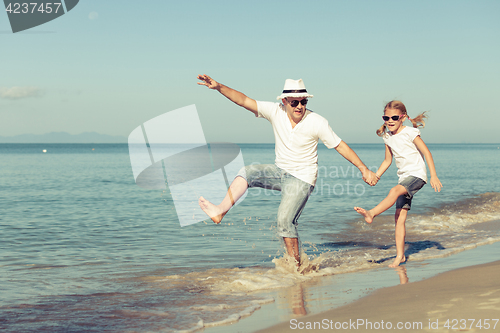 Image of Father and daughter playing on the beach.