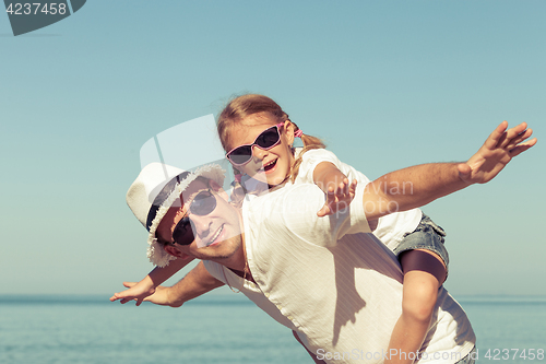 Image of Father and daughter playing on the beach.