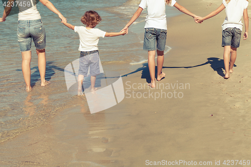 Image of Mother and  children playing on the beach.