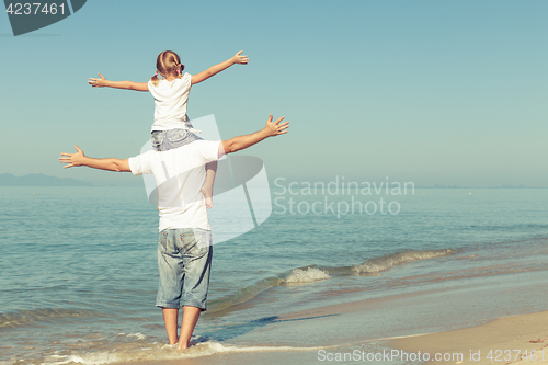 Image of Father and daughter playing on the beach.