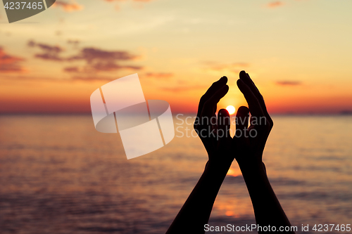 Image of silhouette of female hands during sunset