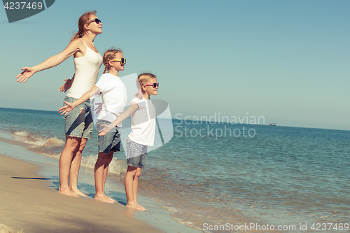 Image of Mother and daughters  playing on the beach at the day time.