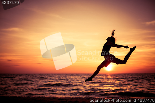 Image of Happy teen girl  jumping on the beach