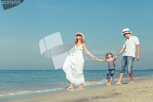 Image of Happy family walking on the beach at the day time. 