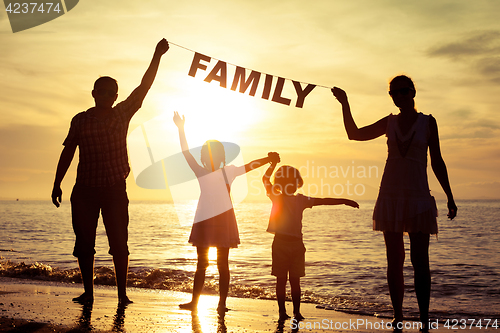 Image of Happy family standing on the beach