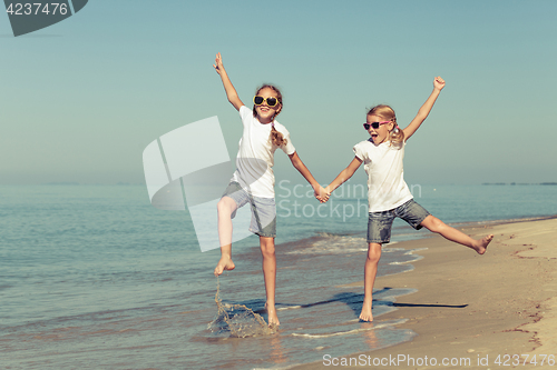 Image of two sisters playing on the beach