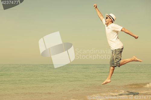 Image of Happy man jumping on the beach