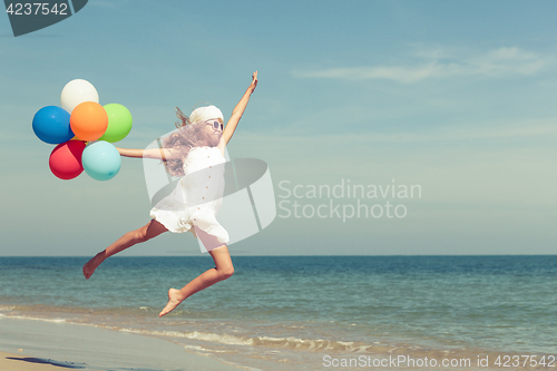 Image of Teen girl  jumping on the beach