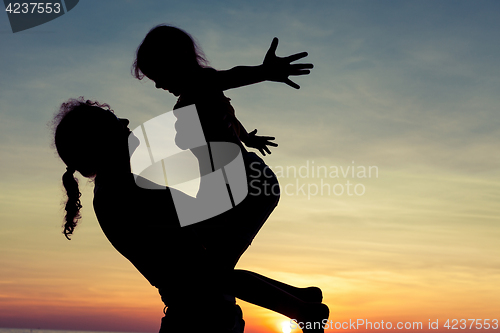 Image of mother and  daughter playing on the beach