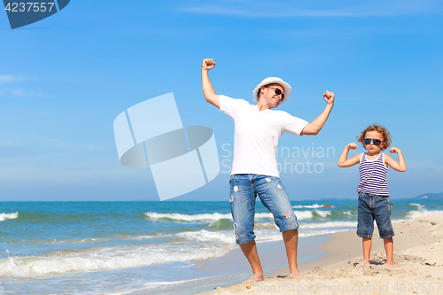 Image of Father and son playing on the beach at the day time. 