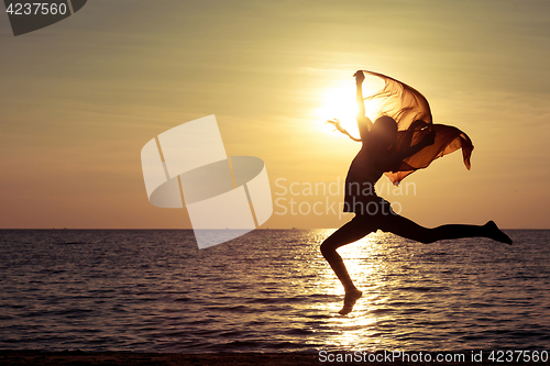 Image of Happy girl jumping on the beach