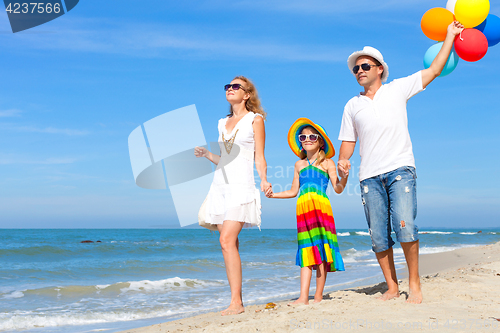 Image of Happy family playing  with balloons on the beach at the day time