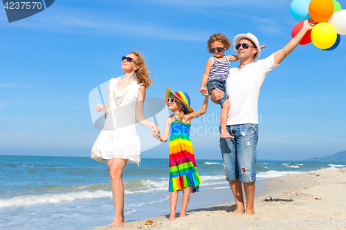 Image of Happy family playing  with balloons on the beach at the day time