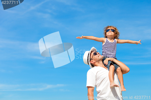 Image of Father and son playing on the beach at the day time.