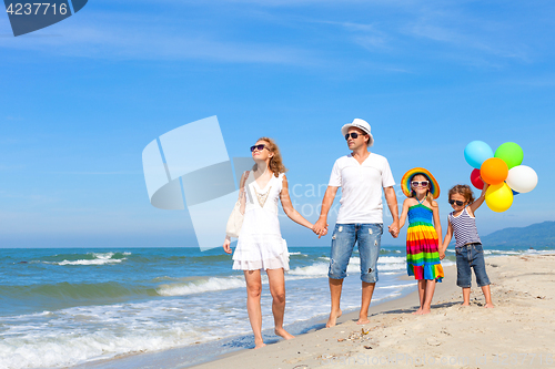 Image of Happy family playing  with balloons on the beach at the day time