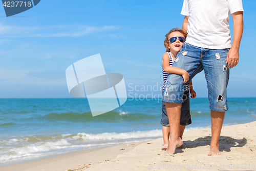 Image of Father and son playing on the beach at the day time.