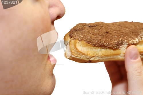 Image of Close up of a young woman eating a cake eclair over white background.