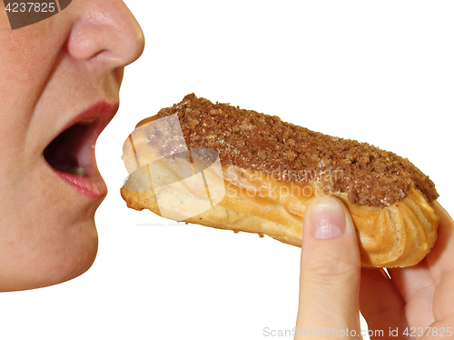 Image of Close up of a young woman eating a cake eclair over white background.