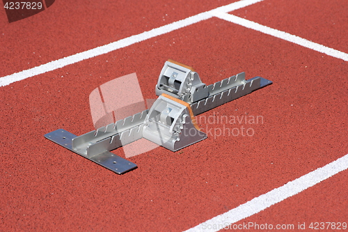 Image of Athletics starting blocks on race red track