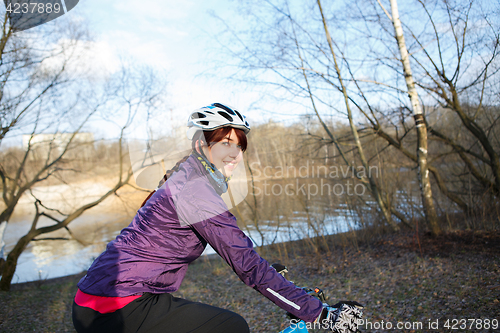 Image of Woman rides bicycle at park