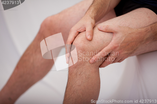 Image of Man holding his knee