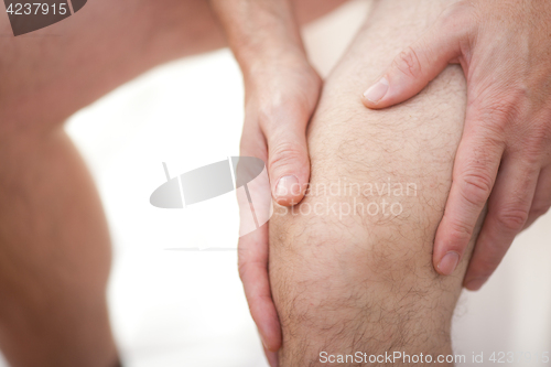 Image of Man holding his knee
