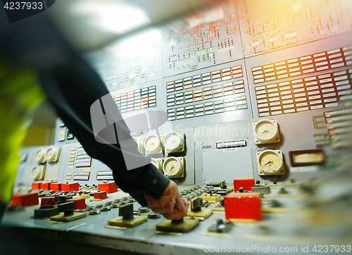 Image of Hand on the control panel of a power plant