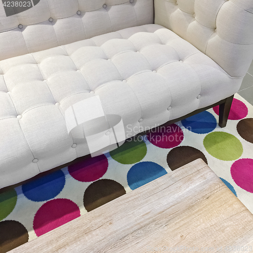 Image of Elegant white sofa on a bright rug