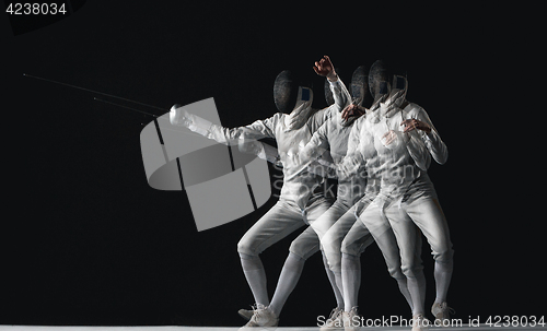 Image of Full-length portrait of woman wearing white fencing costume on black