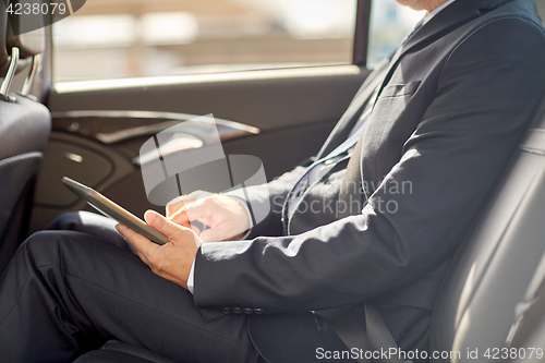 Image of senior businessman with tablet pc driving in car