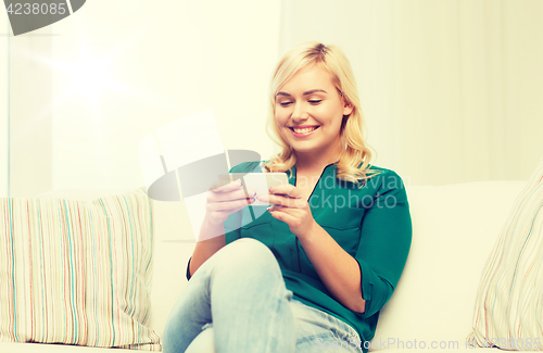 Image of happy woman with smartphone at home