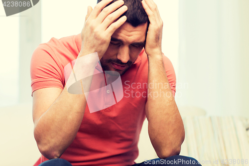 Image of unhappy man suffering from head ache at home