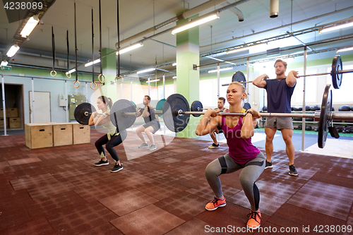 Image of group of people training with barbells in gym