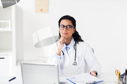 Image of doctor with laptop and clipboard at hospital
