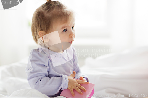 Image of happy little baby girl with gift box at home