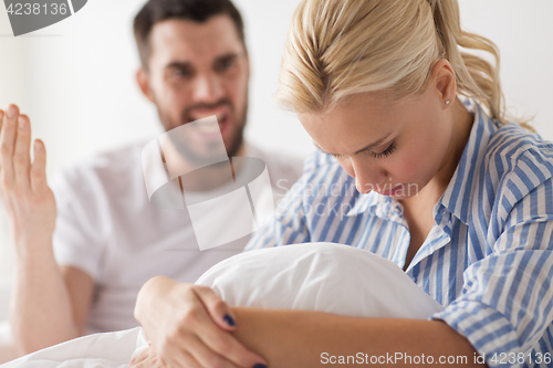 Image of unhappy couple having conflict in bed at home