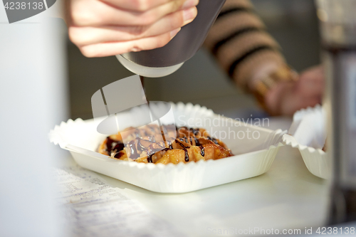 Image of close up of cook adding syrup to waffle