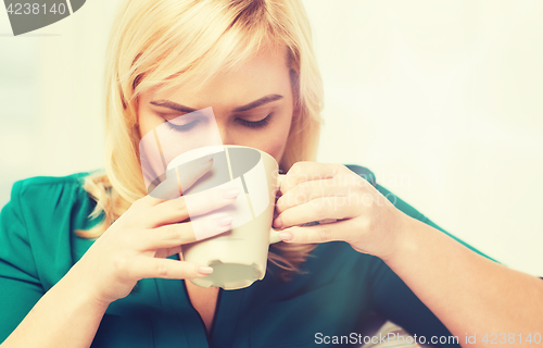 Image of happy woman  with cup of tea or coffee at home