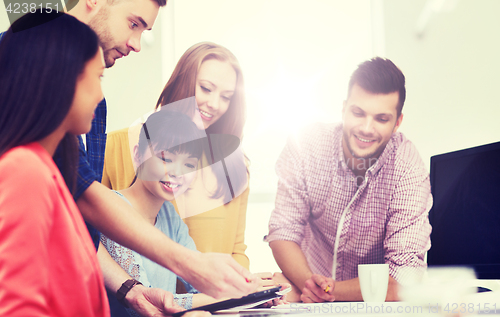 Image of happy creative team with tablet pc at office