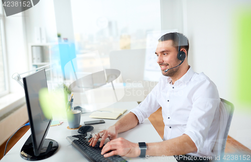 Image of businessman with headset and computer at office