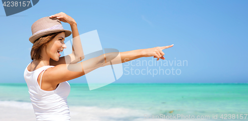 Image of happy young woman in hat on summer beach