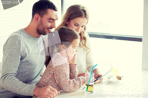 Image of happy family with tablet pc at restaurant