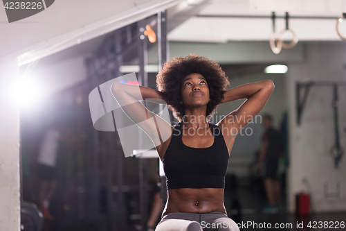 Image of black woman doing sit ups at the gym