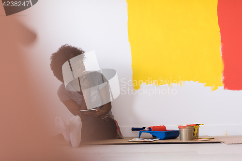 Image of back female painter sitting on floor